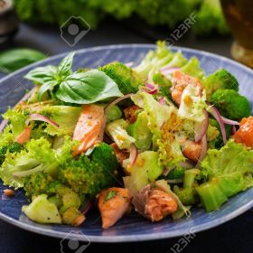 Salad of stewed fish salmon, broccoli, lettuce and dressing. Fish menu. Dietary menu. Seafood - salmon.